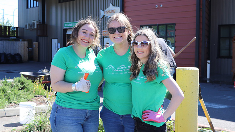 Outdoor photo of three young female volunteers